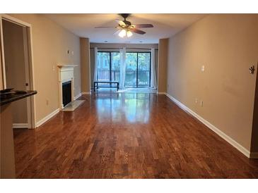 Spacious living room with hardwood floors, fireplace, and sliding glass doors to a balcony at 2303 Pine Heights Ne Dr, Atlanta, GA 30324