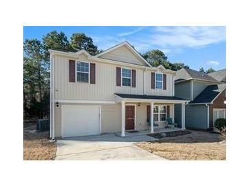 Charming two-story home featuring a front porch, garage, and traditional architectural details at 5987 Westchase St, Atlanta, GA 30336