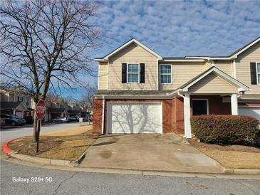 Charming two-story townhome featuring a brick facade and an attached single-car garage at 303 Tara Commons Cir, Loganville, GA 30052