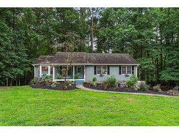 Charming single-story home with blue siding, black shutters, and a well-manicured front yard at 3861 Riding Sw Trl, Powder Springs, GA 30127