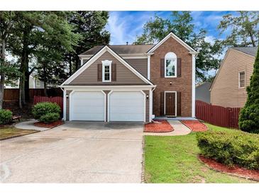 Charming two-story home featuring a two-car garage, manicured lawn, and a blend of siding and brick facade at 914 Wenham Ln, Lawrenceville, GA 30044