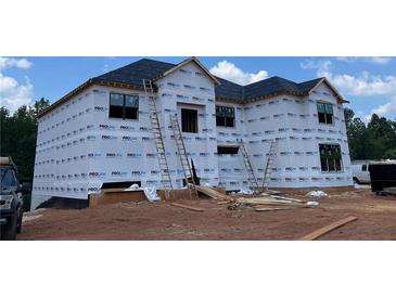 New home construction featuring a house wrapped in weather resistant material and ladders at 3063 Reserve Ct Sw, Conyers, GA 30094