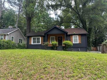 Charming one-story home with a freshly painted exterior, a well-manicured lawn, and mature trees at 1846 North Ave, Atlanta, GA 30318