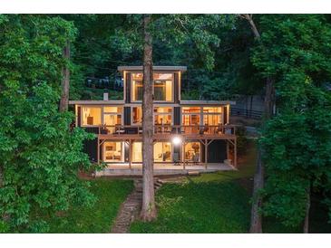 Contemporary home with expansive windows and a large deck nestled amongst mature trees at 132 Lakeshore Dr, Roswell, GA 30075