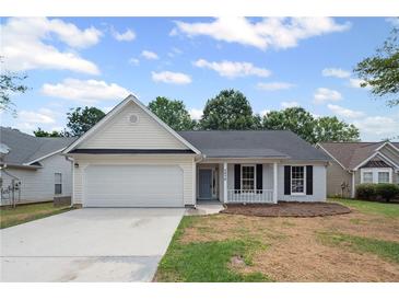 Charming one-story home with white siding, a two-car garage, and a well-maintained front lawn at 2470 Hillvale Cir, Lithonia, GA 30058