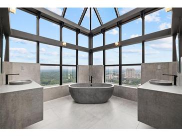 Bright bathroom featuring modern sinks, a stylish tub and window views overlooking the city at 2828 Peachtree Nw Rd # P 3300, Atlanta, GA 30305