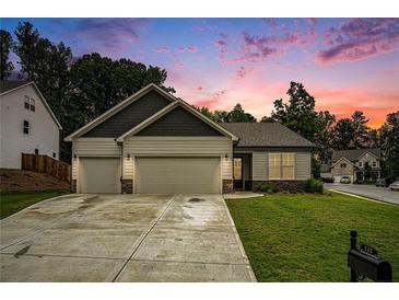 Charming one-story home with a two-car garage and inviting curb appeal, set against a colorful sunset backdrop at 122 Riverbirch Way, Dallas, GA 30157