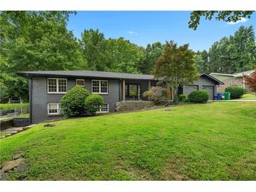 Charming single-story house features a brick facade and a lush green lawn at 2661 Fleur De Lis Pl, Atlanta, GA 30360