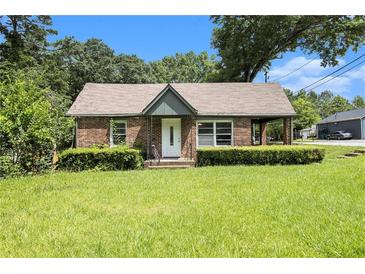 Charming brick home featuring a well-manicured lawn and mature trees at 3530 E Ponce De Leon Ave, Scottdale, GA 30079