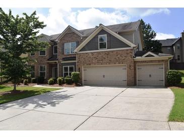 Two-story brick home featuring a two-car garage and a well-maintained lawn at 1365 Slate Bend Dr, Dacula, GA 30019