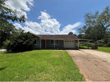 A single story home with a well manicured front yard and a driveway leading up to the garage and covered parking at 3217 Canterbury Trl, Rex, GA 30273
