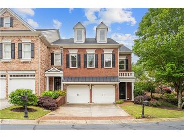 Beautiful brick townhome with two-car garage, dormer windows, and well-manicured landscaping at 11945 Dancliff Trce, Alpharetta, GA 30009