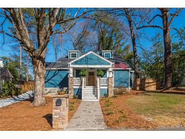 Charming blue home with stone accents, landscaped yard and American flag at 1555 Steele Nw Dr, Atlanta, GA 30309