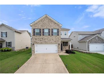 Two-story brick home with a two car garage and a well manicured lawn on a bright sunny day at 7644 Rudder Cir, Fairburn, GA 30213
