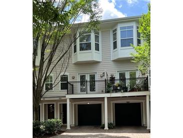 Inviting townhome featuring bay windows, a balcony, and attached garages, perfect for comfortable living at 793 Inman Mews Ne Dr, Atlanta, GA 30307