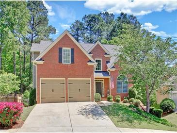 Beautiful brick home with a well-manicured lawn, two-car garage, and charming front yard landscaping at 25 Nunnally Pl, Villa Rica, GA 30180