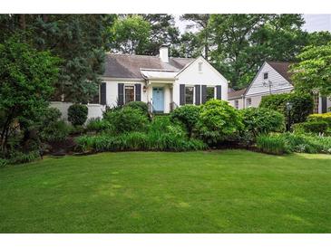 Charming white home with a well-manicured front yard and vibrant landscaping at 657 E Paces Ferry Ne Rd, Atlanta, GA 30305