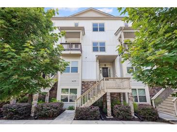Charming three-story townhome with stone accents, inviting staircase, and lush green landscaping at 3116 Quantum Ln, Atlanta, GA 30341