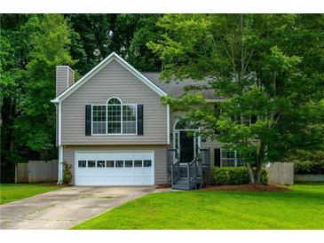 Charming two-story home features a manicured lawn, attached garage and beautiful landscaping at 5137 Allison Way, Sugar Hill, GA 30518