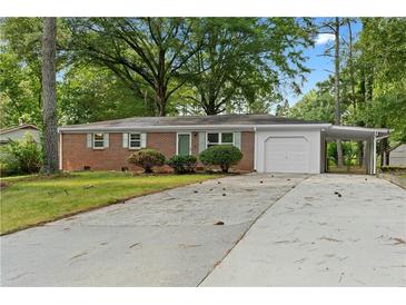 Charming brick home featuring a garage and carport, surrounded by mature trees and a spacious driveway at 3152 Ridgecrest Dr, Powder Springs, GA 30127