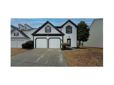Charming two-story home featuring an attached two-car garage, neutral siding, and well-maintained landscaping at 2587 Alvecot Se Cir, Atlanta, GA 30339