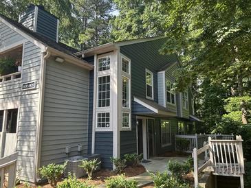 Two-story home with gray and blue siding, white trim, large windows, and front yard foliage at 1404 N Crossing Ne Dr, Atlanta, GA 30329