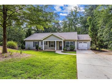 Charming single-story home with manicured lawn, mature trees, and an attached one-car garage at 5706 Forest Pl, Acworth, GA 30102