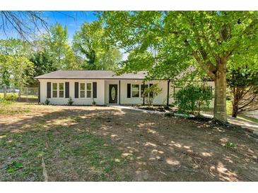 Charming single-story home featuring a black front door, black shutters and a beautifully landscaped front yard at 144 Cathy Ln, Hiram, GA 30141