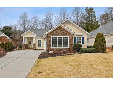 Charming one-story home with stone accents, manicured landscaping, and a welcoming front porch at 6775 Marlow Dr, Cumming, GA 30041