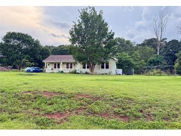 Charming single-story home with a spacious lawn, mature trees, and a welcoming front porch at 107 Bowen Rd, Stockbridge, GA 30281
