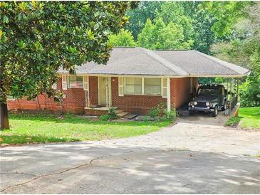 Cozy single-story brick home featuring a front lawn, carport, and easy driveway access at 1900 Columbia Dr, Decatur, GA 30032