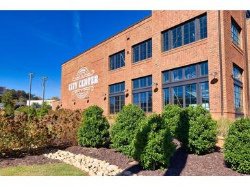Brick building with 'City Center' signage, complemented by manicured landscaping and bright blue skies at 4625 Greyson Manor Dr, Cumming, GA 30041