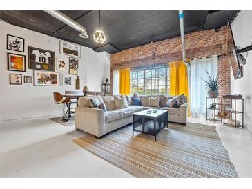 Inviting living room with exposed brick, modern lighting, and comfortable seating area at 881 Memorial Se Dr # 116, Atlanta, GA 30316