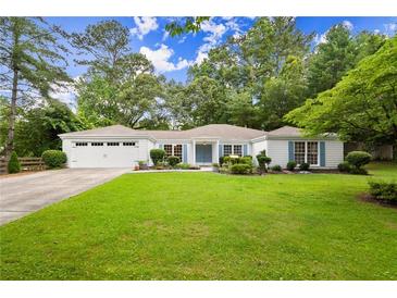 Charming single-story home with lush green lawn, blue shutters, and a two-car garage at 3545 Turtle Cove Se Ct, Marietta, GA 30067