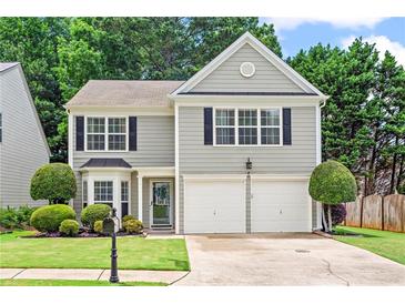 Charming two-story home featuring a manicured lawn, a two-car garage and traditional architectural details at 585 Ashland Pkwy, Woodstock, GA 30189