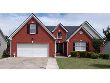 Charming red brick home with a well-manicured lawn and two-car garage in a suburban neighborhood at 2645 Barkley Manor Dr, Lawrenceville, GA 30044