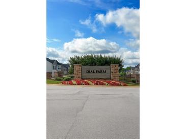 Inviting 'Dial Farm' community sign with colorful flower beds, brick pillars, and beautiful blue skies at 89 Cowpen Ct, Covington, GA 30014
