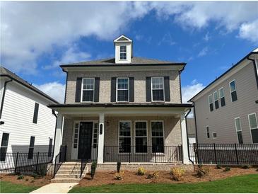 Charming two-story home featuring a brick facade, black shutters, and a welcoming front porch at 163 Basil St, Cumming, GA 30040