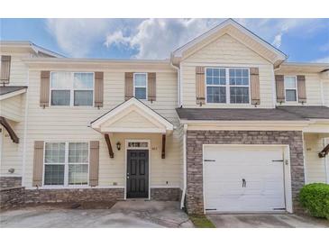 Charming two-story townhouse featuring stone accents, a one-car garage, and inviting front entrance at 4217 High Park Ln, Atlanta, GA 30344