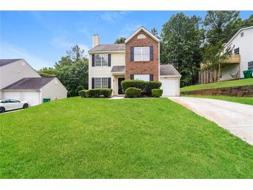 Charming two-story home with brick and siding exterior, manicured lawn and driveway at 6481 Alford Way, Lithonia, GA 30058
