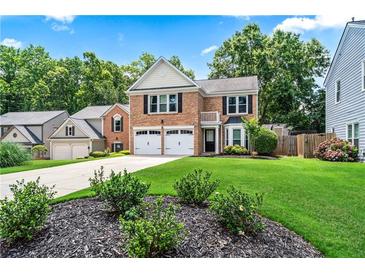 Charming brick two-story home with a well-manicured lawn and a two-car garage at 615 Rosedown Way, Alpharetta, GA 30022