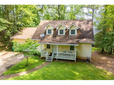 Charming yellow home with a welcoming front porch, surrounded by lush greenery at 9018 Lakeview Pkwy, Villa Rica, GA 30180