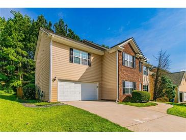 Two-story home featuring brick and siding exterior, attached garage, and a well-maintained front lawn at 5018 Upper Elm St, Atlanta, GA 30349