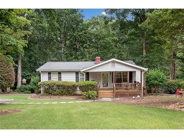 Charming single story home with a covered porch and lush, green landscaped front yard at 307 Little Hickory Ln, Woodstock, GA 30189