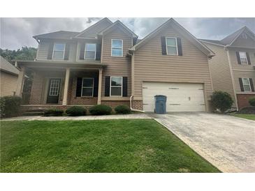 Charming two-story home with a well-manicured lawn and attached two-car garage at 443 Strawberry Walk, Loganville, GA 30052