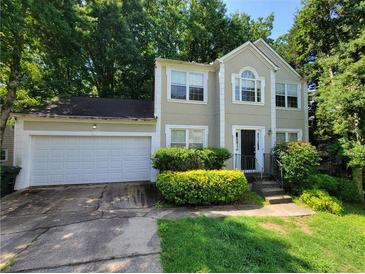 Two-story home featuring manicured landscaping, a two car garage, and traditional architectural design at 180 Preston Oaks Dr, Johns Creek, GA 30022
