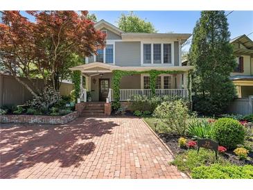 Charming home featuring a brick driveway, landscaped yard, and inviting covered front porch at 22 The Prado Ne, Atlanta, GA 30309