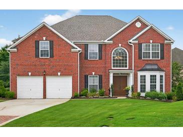 Beautiful two-story red brick home with a well-manicured lawn and a two car garage at 4203 Norbury Ct, Smyrna, GA 30080