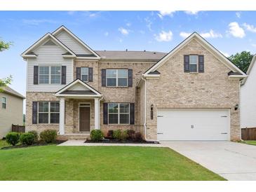 Charming brick two-story home features a manicured lawn and a two-car garage at 5575 Mirror Lake Dr, Cumming, GA 30028