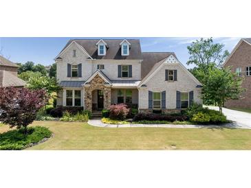 Beautiful two-story home with manicured lawn, stone accents, and charming curb appeal at 5915 Read Rd, Suwanee, GA 30024